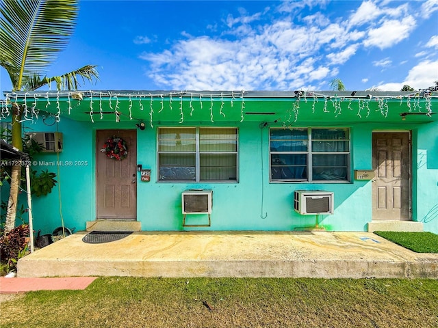 view of front of property with a wall mounted air conditioner