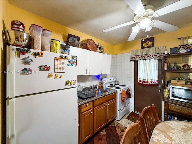 kitchen with ceiling fan, backsplash, white appliances, dark tile patterned flooring, and sink