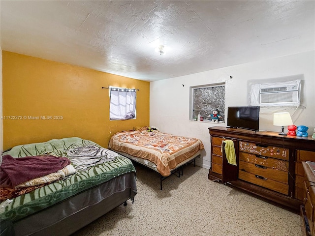 bedroom with a textured ceiling and an AC wall unit