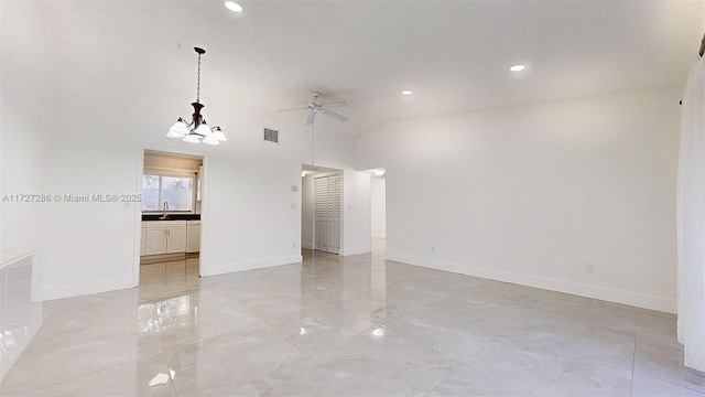 spare room featuring vaulted ceiling and ceiling fan with notable chandelier