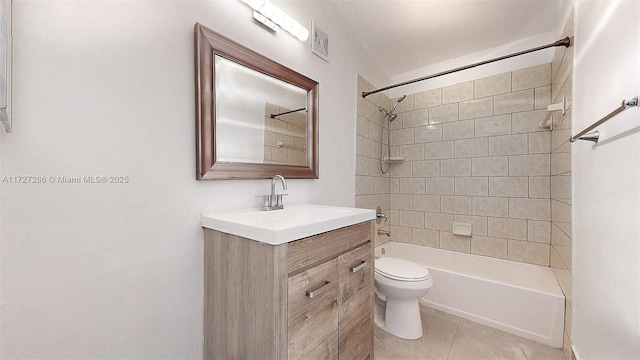 full bathroom with toilet, tiled shower / bath, tile patterned floors, and vanity