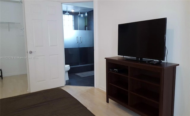 bedroom featuring ensuite bathroom and light hardwood / wood-style flooring