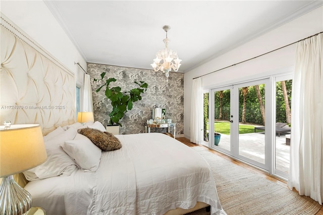 bedroom with hardwood / wood-style floors, access to exterior, a chandelier, french doors, and ornamental molding