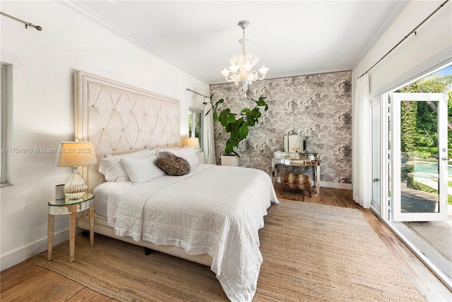 bedroom with crown molding, hardwood / wood-style flooring, and a notable chandelier