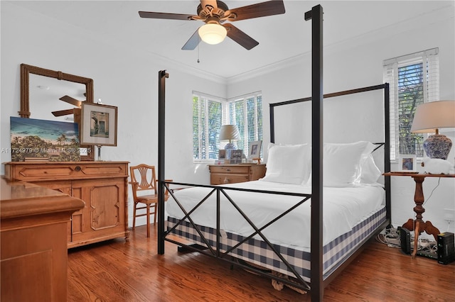 bedroom with ceiling fan, ornamental molding, hardwood / wood-style floors, and multiple windows