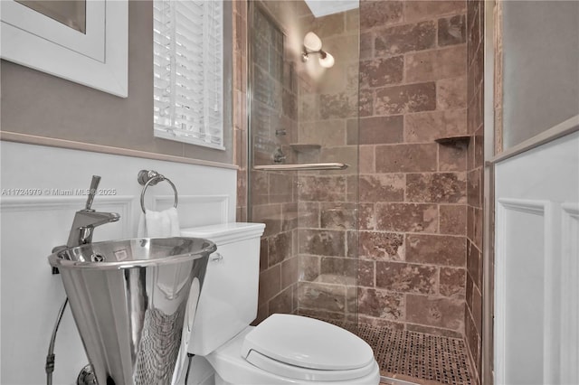 bathroom with toilet and a tile shower