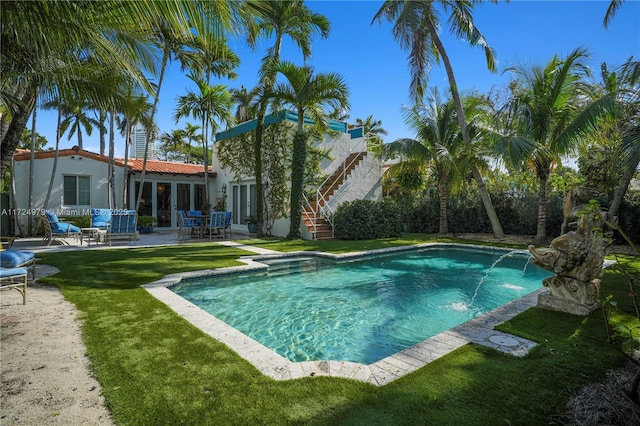 view of pool featuring pool water feature, a patio area, and a yard