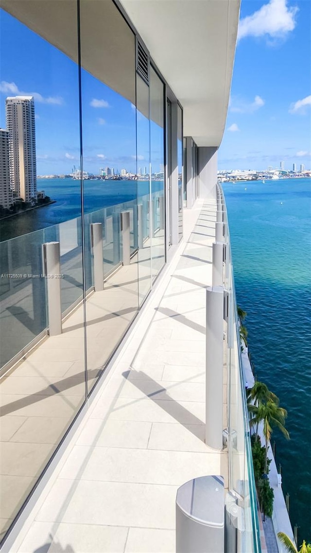 balcony featuring a view of city, a water view, and central AC unit