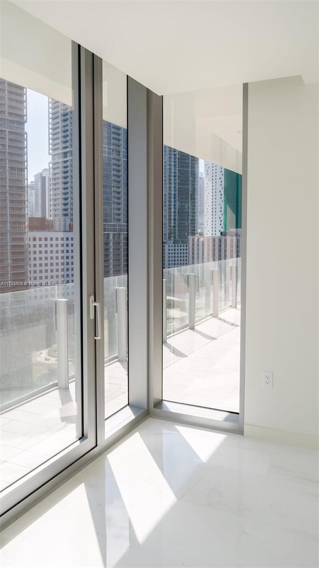 doorway to outside featuring a view of city and floor to ceiling windows