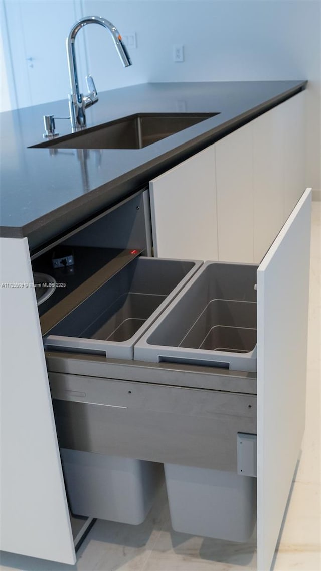 details featuring a sink and white cabinets