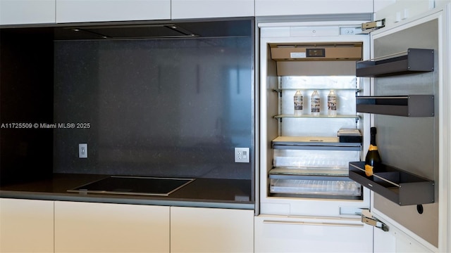 kitchen with open shelves, dark countertops, and white cabinetry