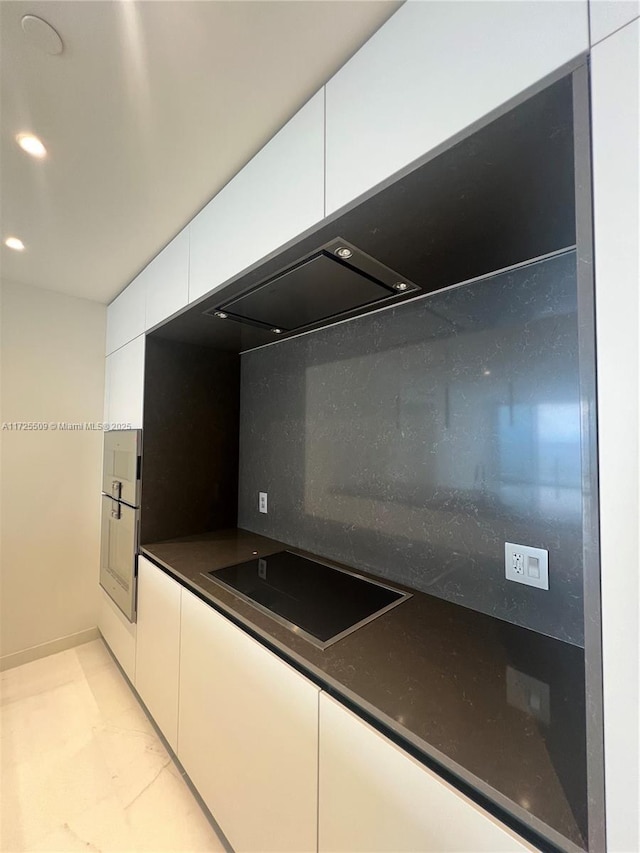 kitchen featuring white cabinetry, black electric cooktop, and tasteful backsplash