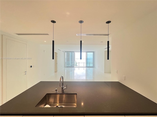 kitchen featuring sink, kitchen peninsula, and decorative light fixtures