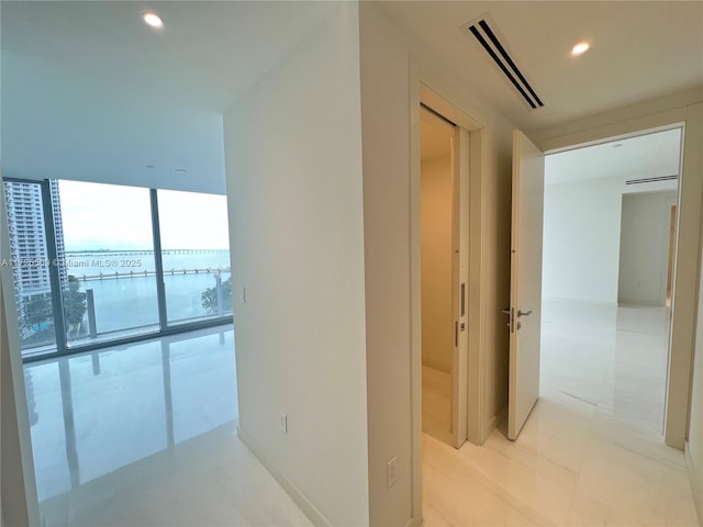 corridor with floor to ceiling windows and a water view