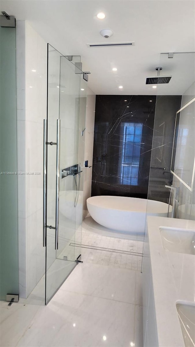 full bathroom featuring a sink, a shower stall, a freestanding bath, and recessed lighting