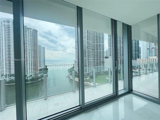 entryway with a water view, a wall of windows, and a healthy amount of sunlight