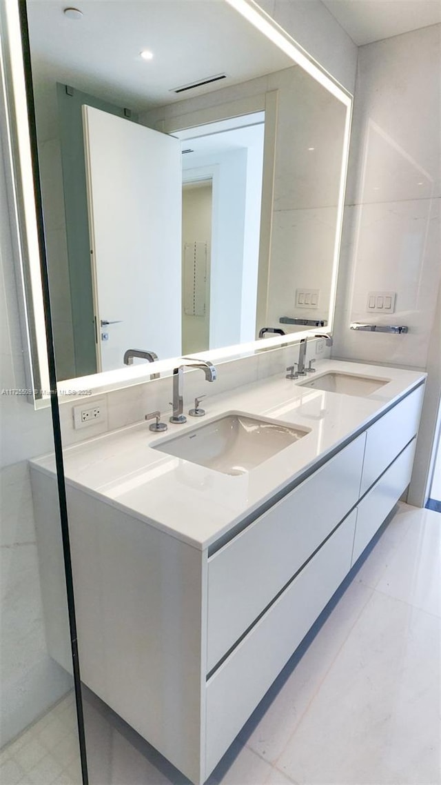 bathroom with double vanity, a sink, and tile patterned floors