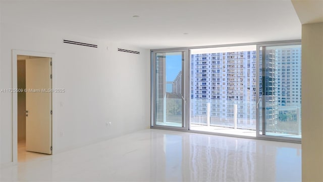 empty room featuring visible vents and floor to ceiling windows