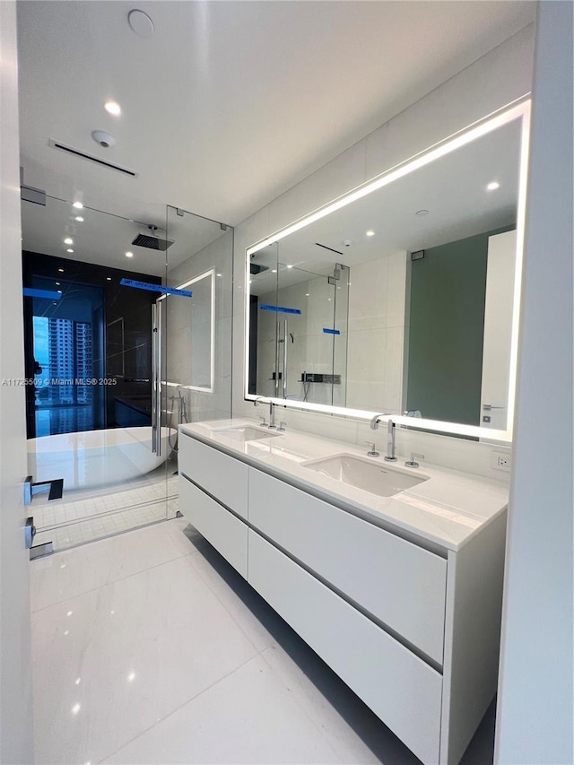 bathroom with an enclosed shower, vanity, and tile patterned flooring