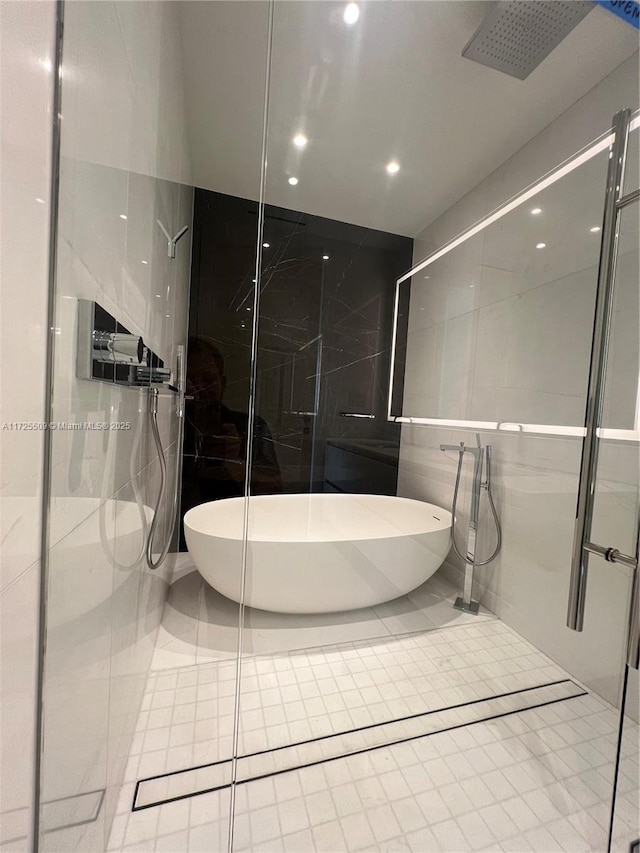 bathroom featuring plus walk in shower, tile walls, and tile patterned floors