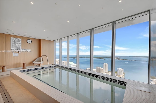 view of pool featuring a water view and a hot tub