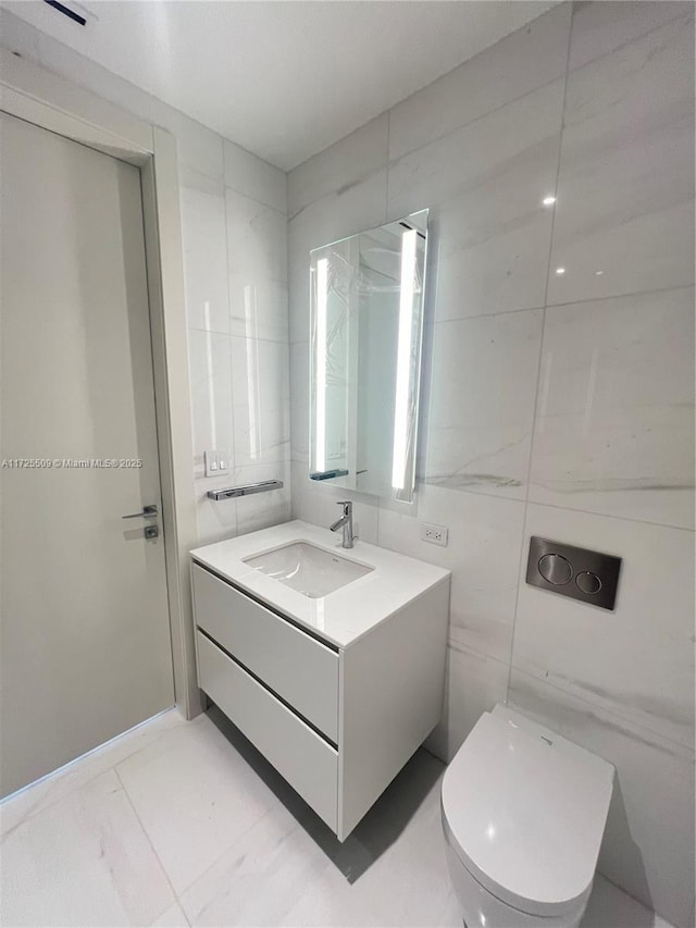 bathroom with tile walls, toilet, and vanity