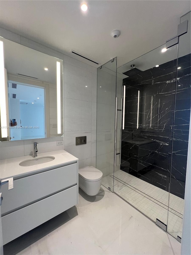 bathroom featuring tile walls, toilet, vanity, and a tile shower