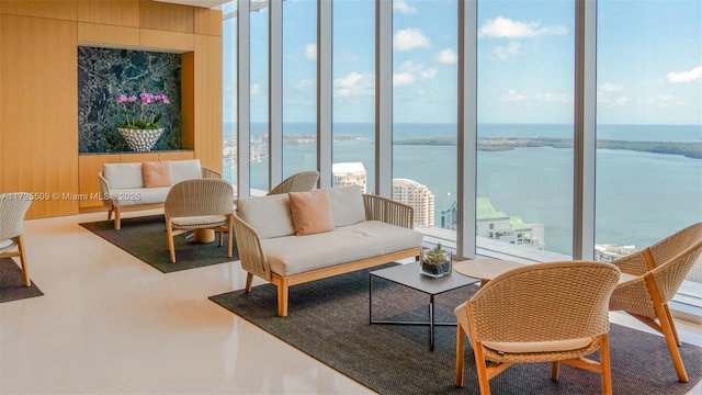 living area with a water view, expansive windows, finished concrete flooring, and a wealth of natural light