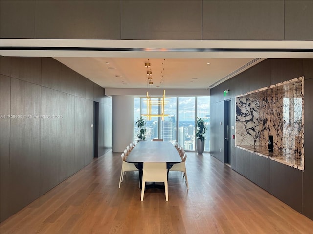 dining space featuring light hardwood / wood-style floors, expansive windows, and an inviting chandelier