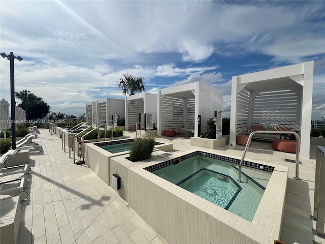 view of swimming pool featuring a hot tub and a patio