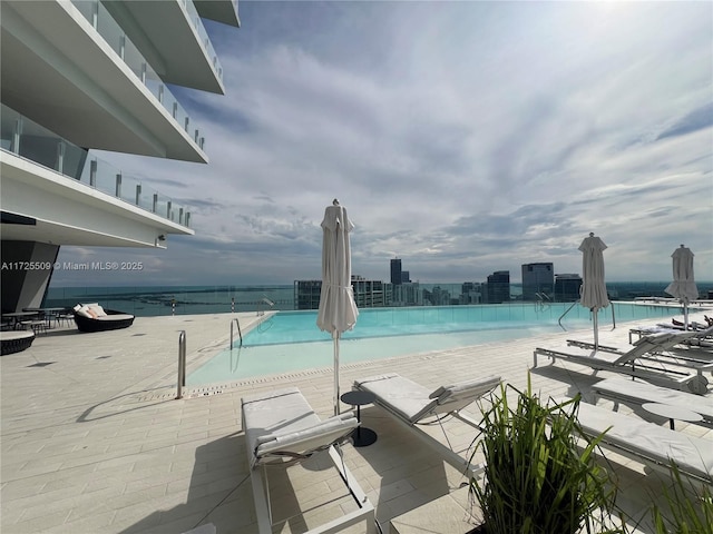 view of swimming pool with a water view and a patio