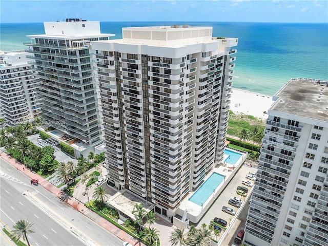 view of building exterior with a water view and a view of the beach