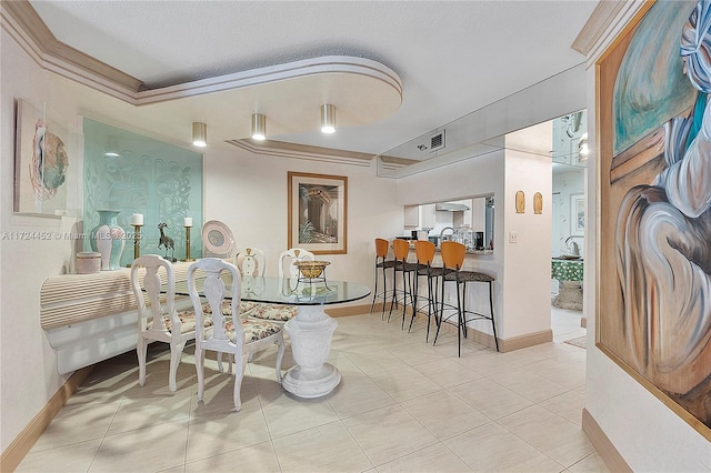 dining space featuring a textured ceiling, light tile patterned floors, and crown molding