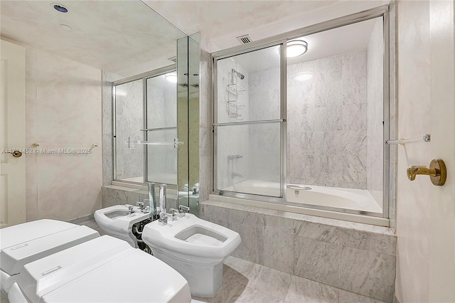 bathroom with toilet, bath / shower combo with glass door, and a bidet