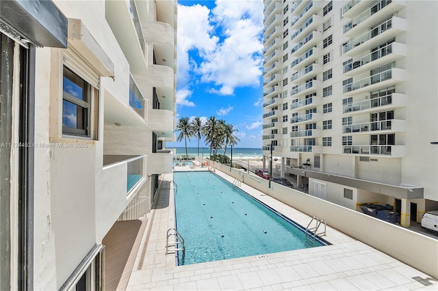 view of pool featuring a patio area and a water view