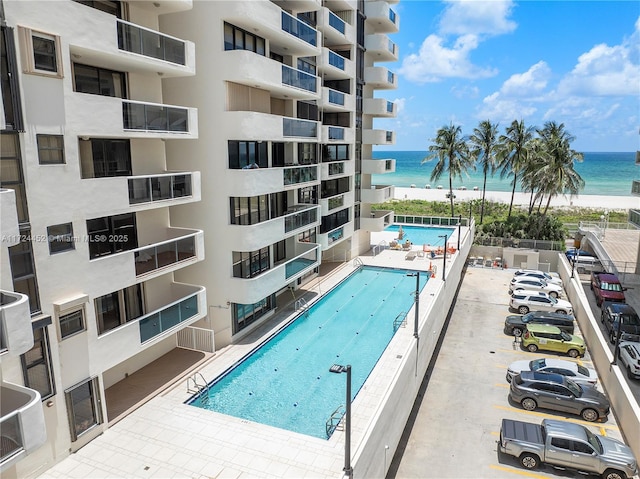 view of swimming pool with a water view and a patio