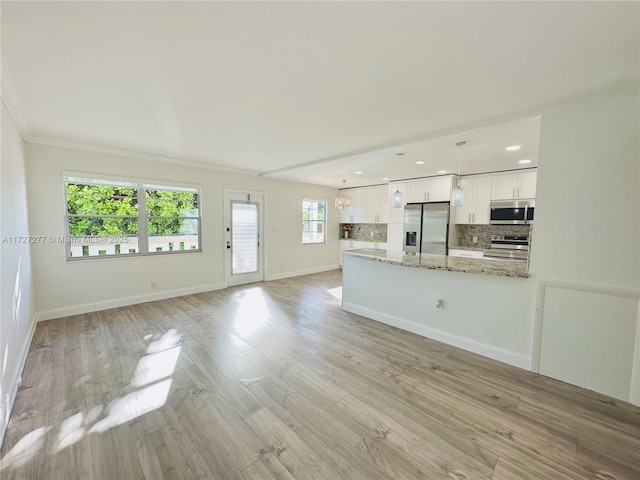 unfurnished living room with light wood-type flooring and crown molding