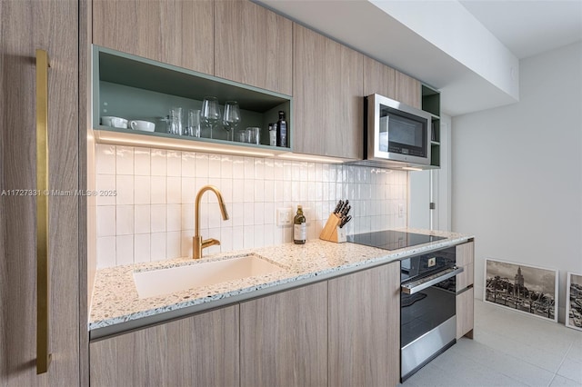 kitchen featuring tasteful backsplash, sink, appliances with stainless steel finishes, light brown cabinetry, and light stone counters