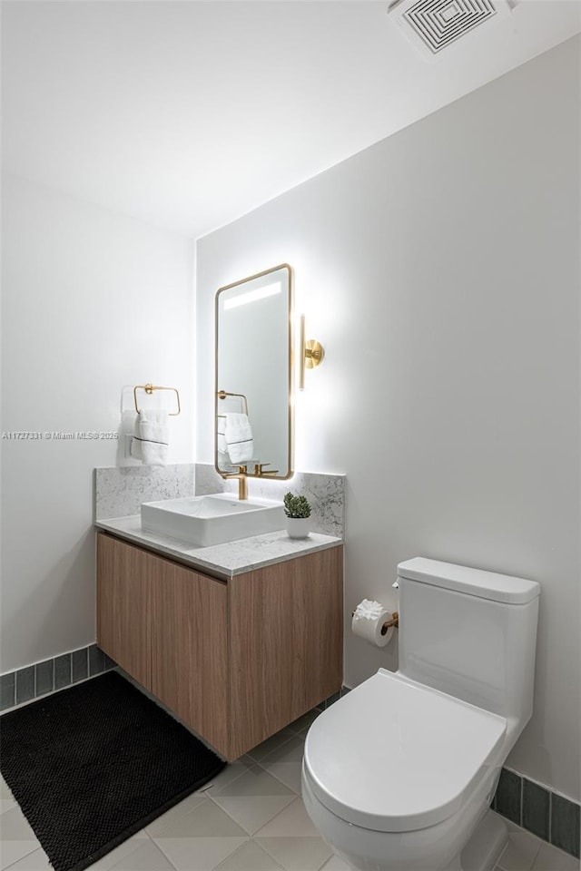 bathroom with toilet, tile patterned flooring, and vanity