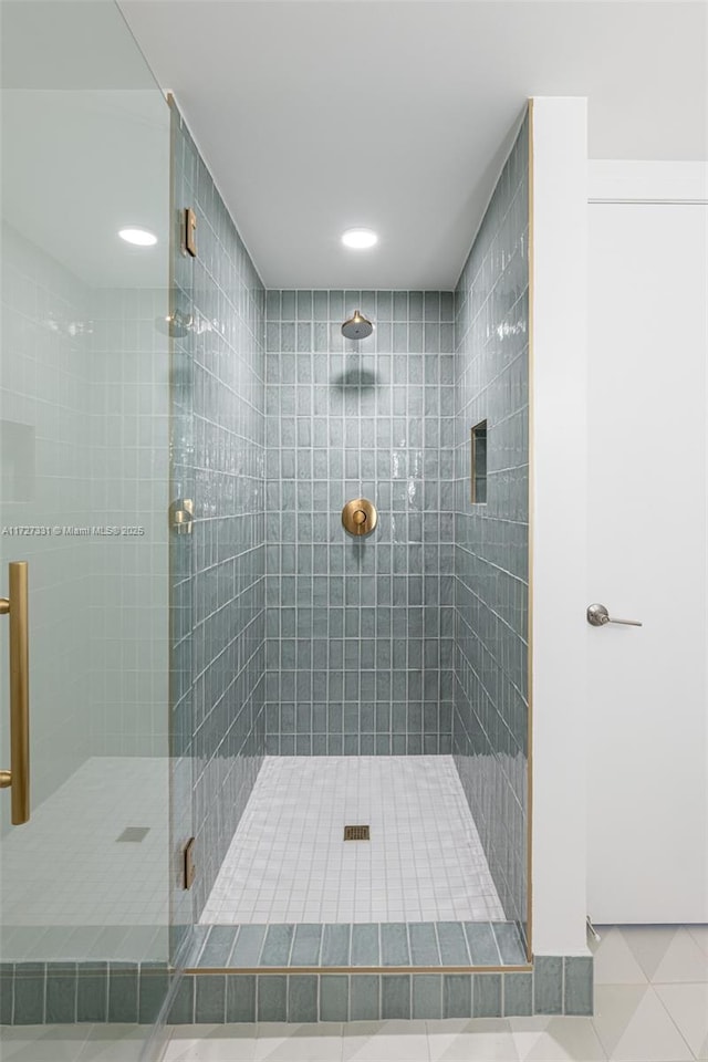 bathroom with tile patterned floors and a shower with door