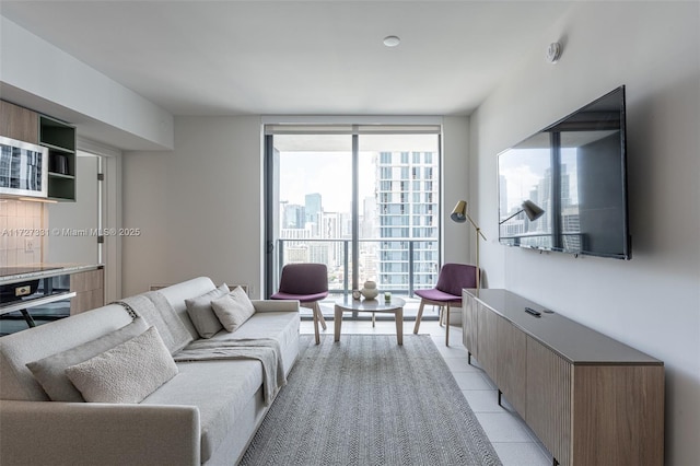 living room featuring expansive windows and light tile patterned floors