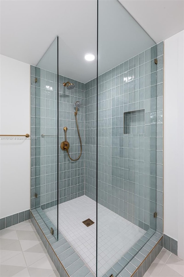 bathroom with tile patterned floors and tiled shower