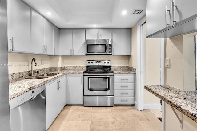 kitchen featuring light tile patterned floors, light stone countertops, sink, and stainless steel appliances