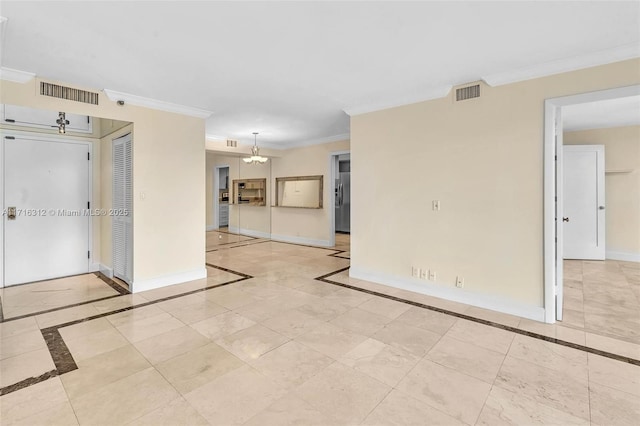 spare room with ornamental molding and a chandelier