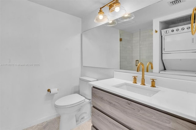 bathroom with toilet, stacked washer and clothes dryer, an enclosed shower, and vanity