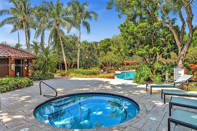 view of pool with a pergola, a community hot tub, and a patio area