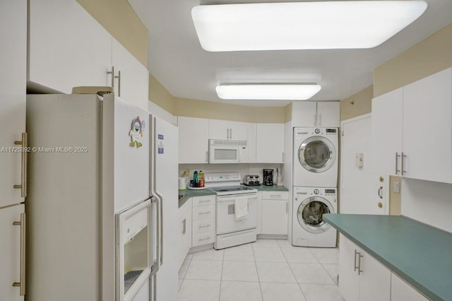 kitchen with stacked washer / dryer, white appliances, light tile patterned floors, and white cabinetry