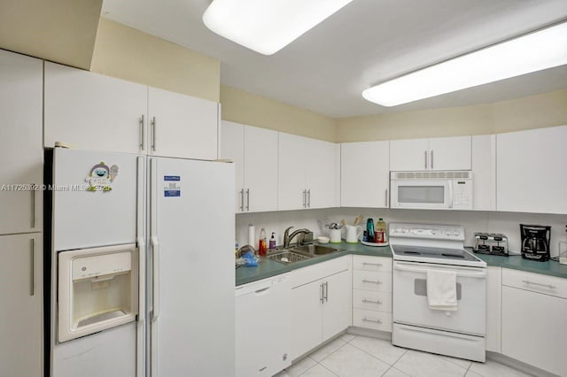 kitchen with sink, white appliances, white cabinets, and light tile patterned flooring