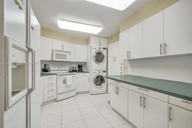 kitchen featuring white cabinetry, white appliances, stacked washing maching and dryer, and light tile patterned flooring