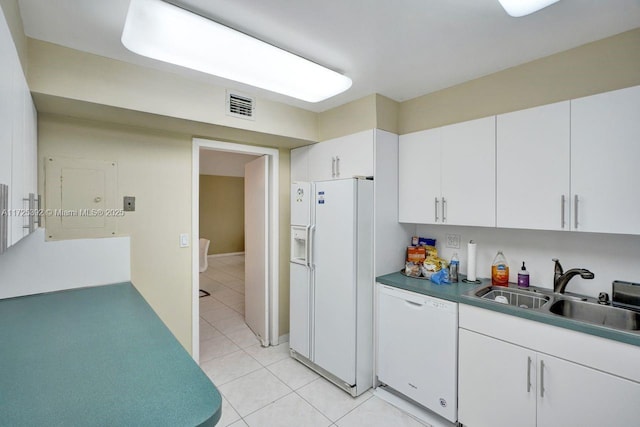 kitchen with sink, white appliances, white cabinets, and light tile patterned flooring